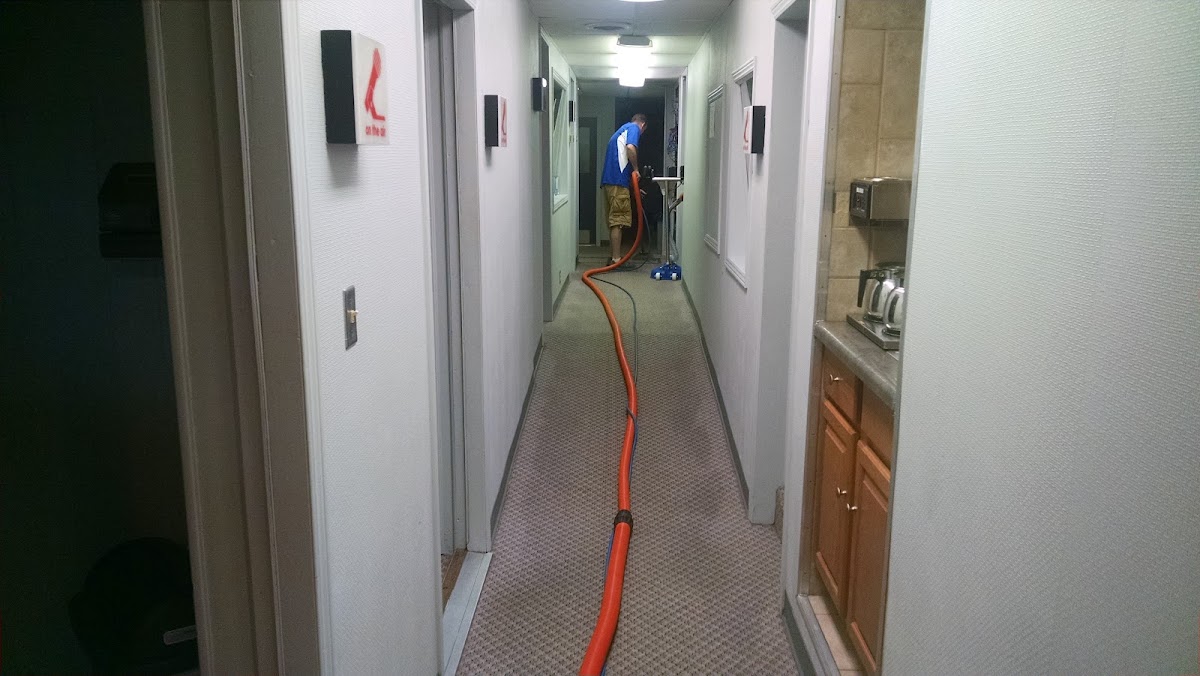Hose run down an apartment hallway during a carpet clean